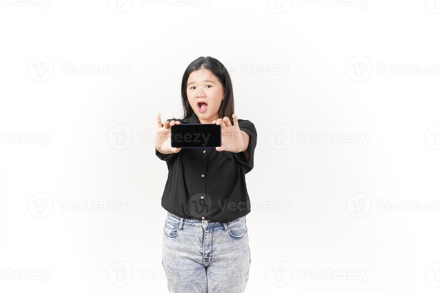 Young Asian woman presenting blank screen of Smartphone wearing Black t-shirt and jeans isolated on white background photo