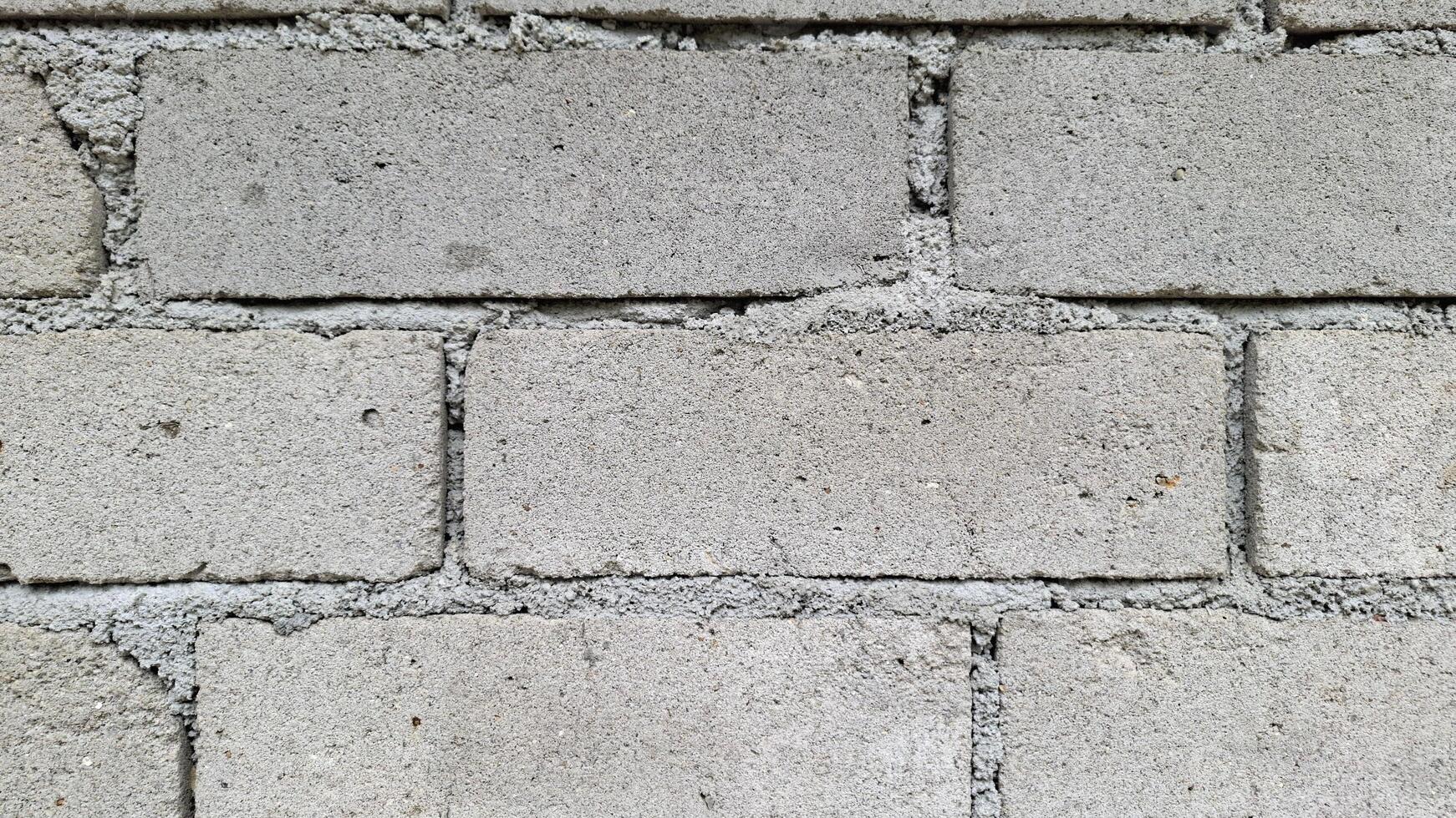 A close up of a concrete block wall The textured surface has a rough uneven look photo