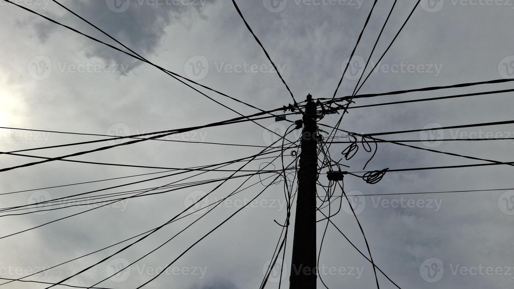 A tangled mess of power lines against a cloudy sky urbanjungle electricity overheadwires sky photo