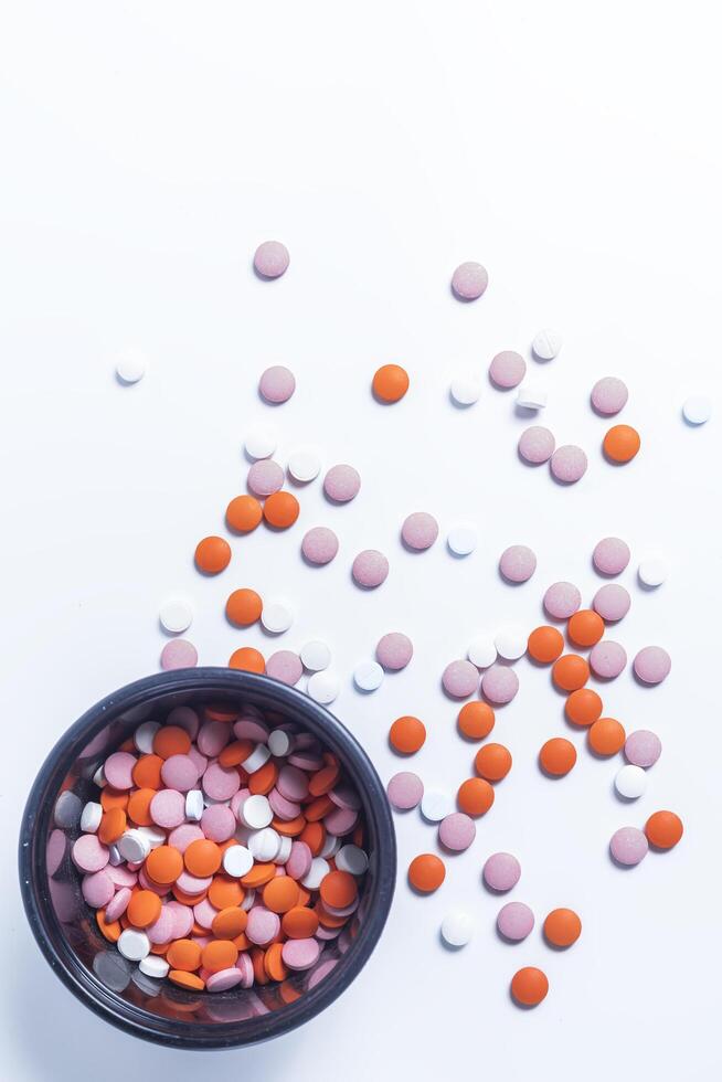 Colorful pills in black plastic box on white background. photo