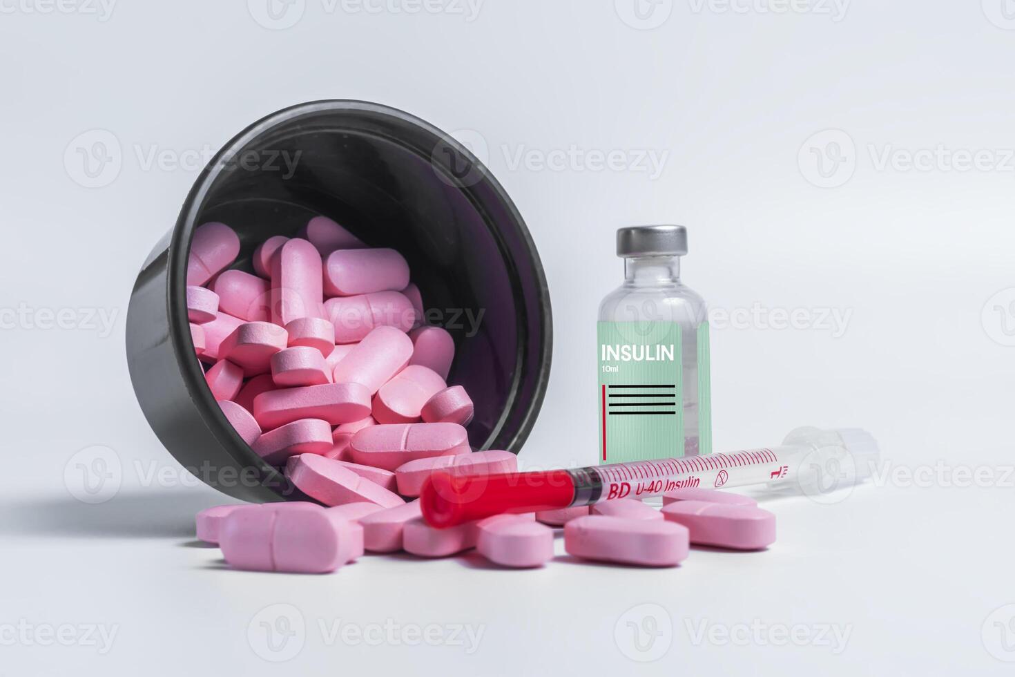 Vaccine bottle with spilled pink pills and syringe on side on white background. photo