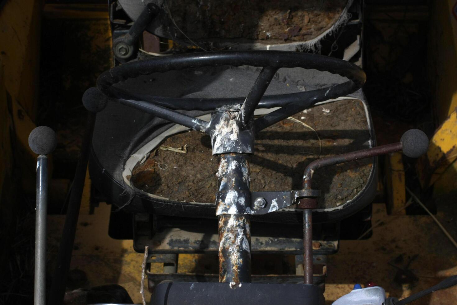 Close-up of an abandoned backhoe loader cockpit, showcasing worn controls and faded dials, capturing a sense of neglect and industrial decay. photo