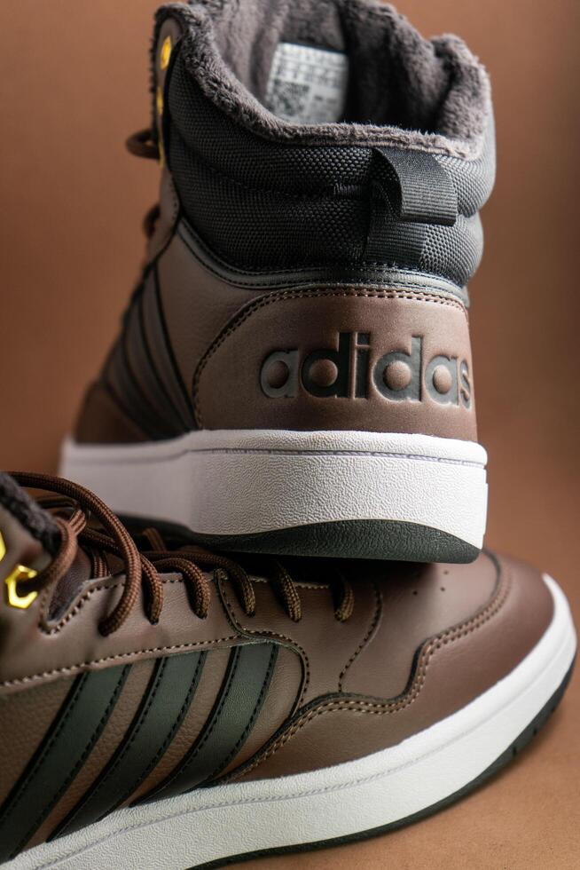 Evora, Portugal. March 3, 2024. Adidas brown boots on a matching brown background, highlighting sleek design and rugged texture. Perfect for outdoor adventures and style. photo
