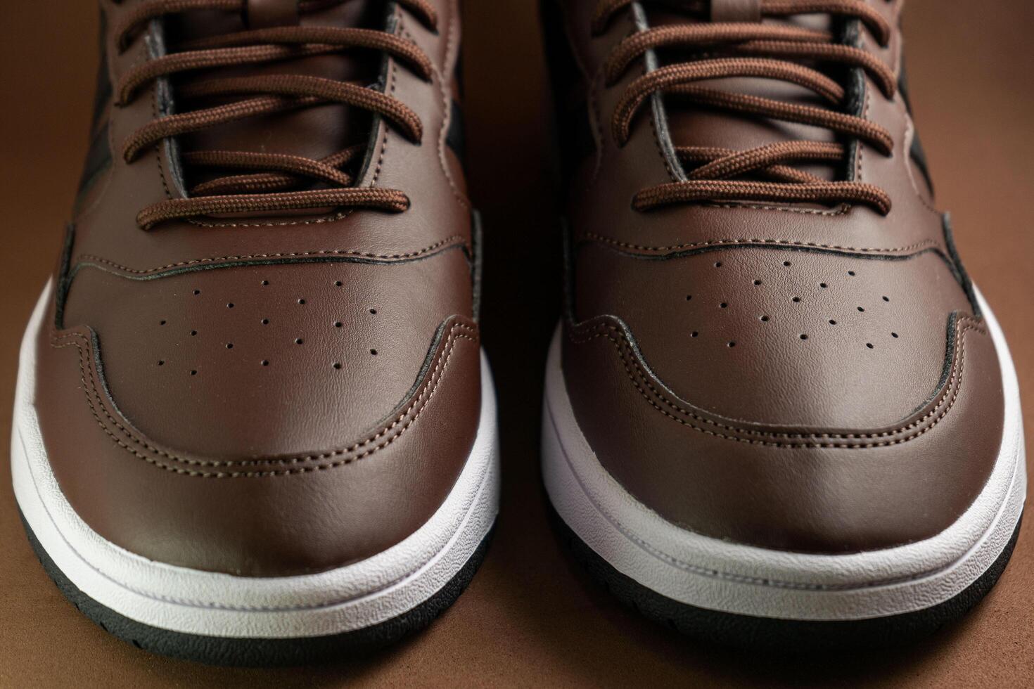 Evora, Portugal. March 3, 2024. Adidas brown boots on a matching brown background, highlighting sleek design and rugged texture. Perfect for outdoor adventures and style. photo