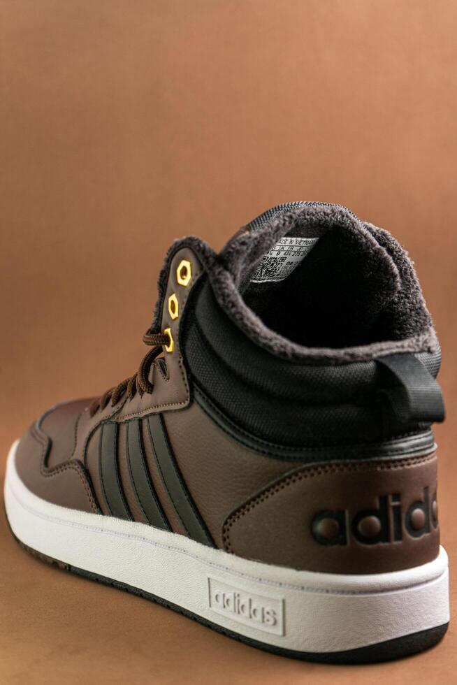 Evora, Portugal. March 3, 2024. Adidas brown boots on a matching brown background, highlighting sleek design and rugged texture. Perfect for outdoor adventures and style. photo
