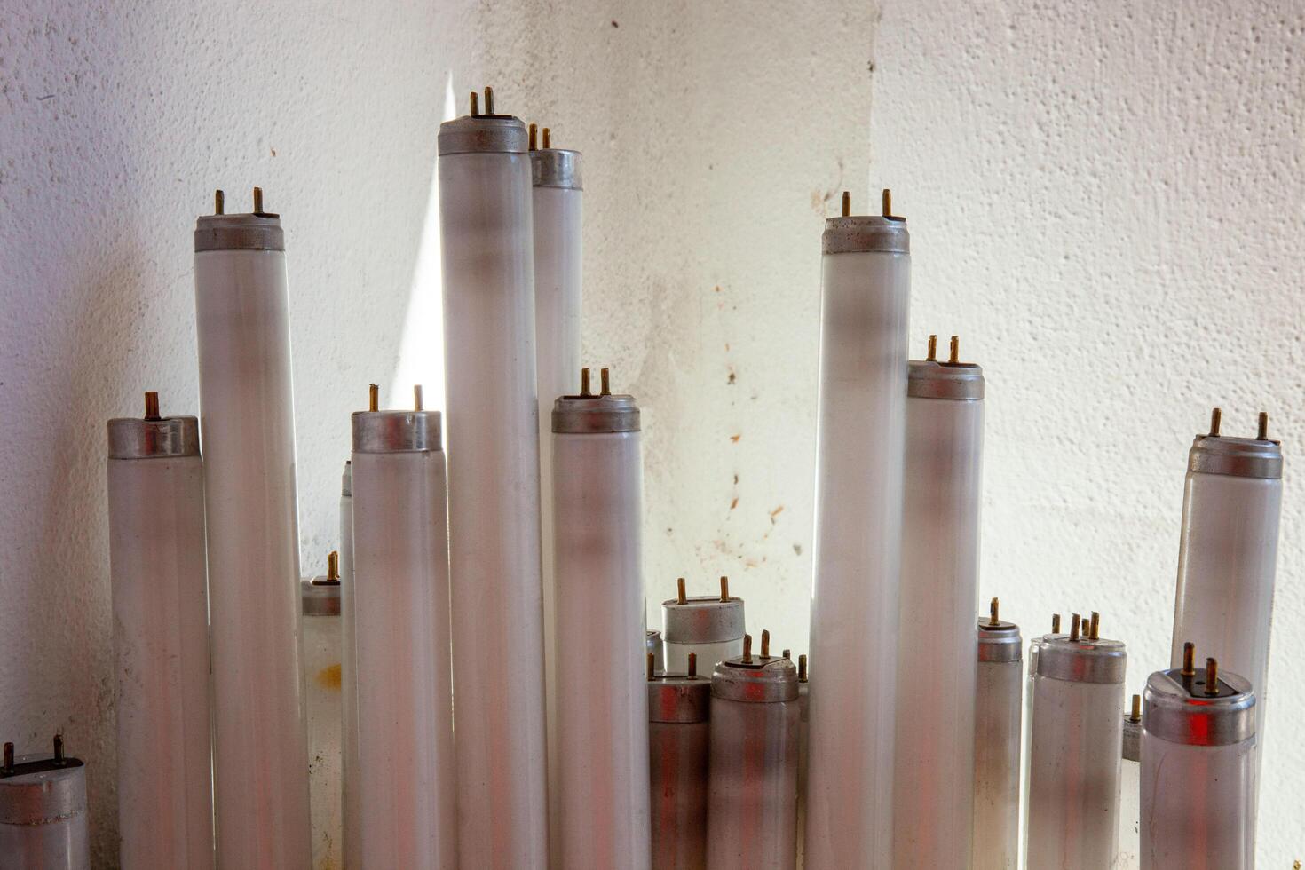 A pile of discarded fluorescent light bulbs, ready for recycling. The image emphasizes environmental responsibility and sustainable waste management. photo