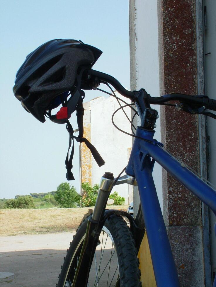 Mountain bike leaning against a wall, with helmet hanging on the handlebar. Perfect for outdoor adventure, cycling, and sports themes. Ideal for stock photography use. photo