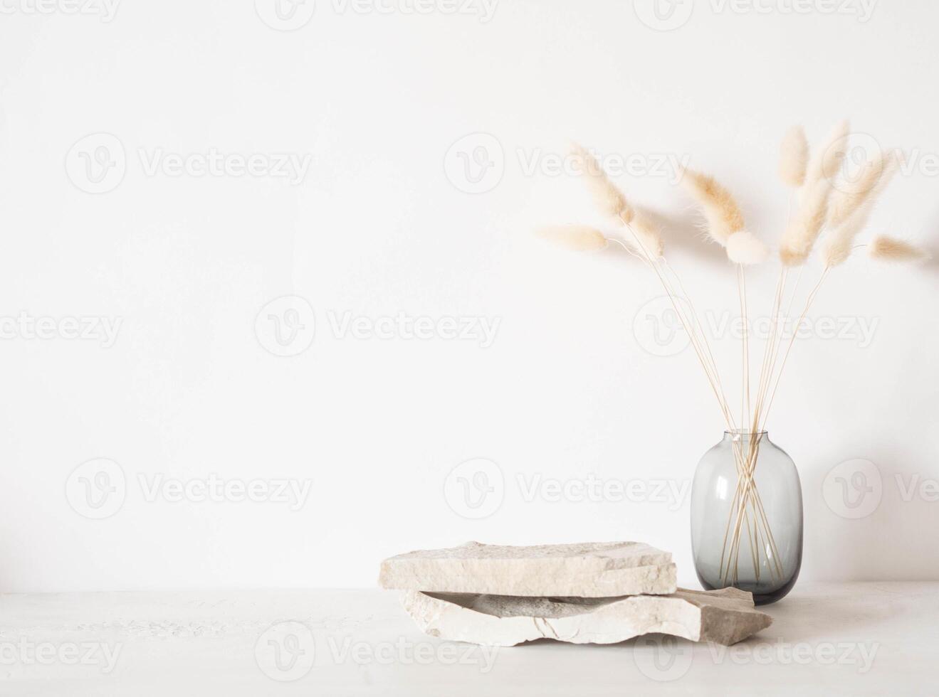Grey natural stones podium on white background, platform for product display and dry branches in vase photo