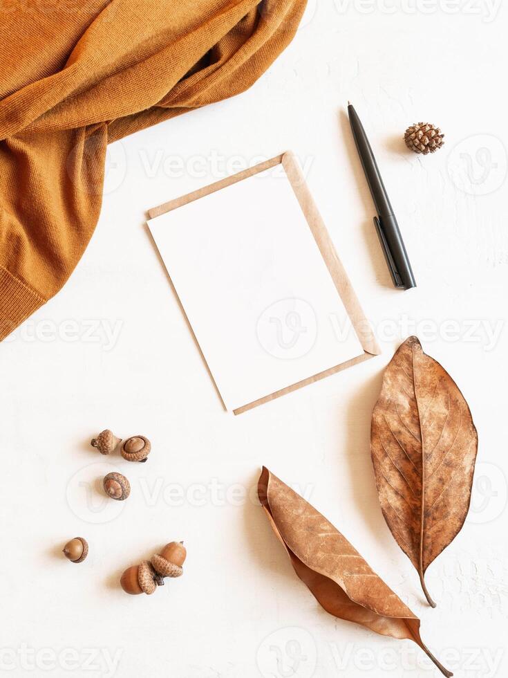 Frame from brown sweater, fall leaf and acorns, envelope and postcard photo