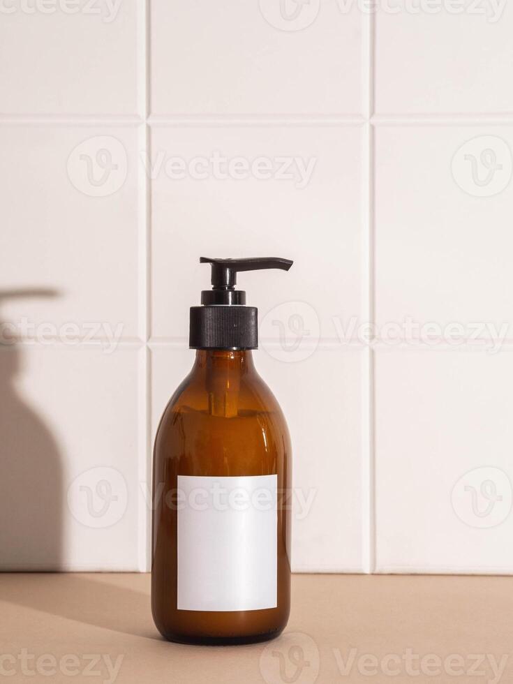 Amber bottle with white label mockup for bathing products in bathroom, spa shampoo, shower gel, liquid soap photo