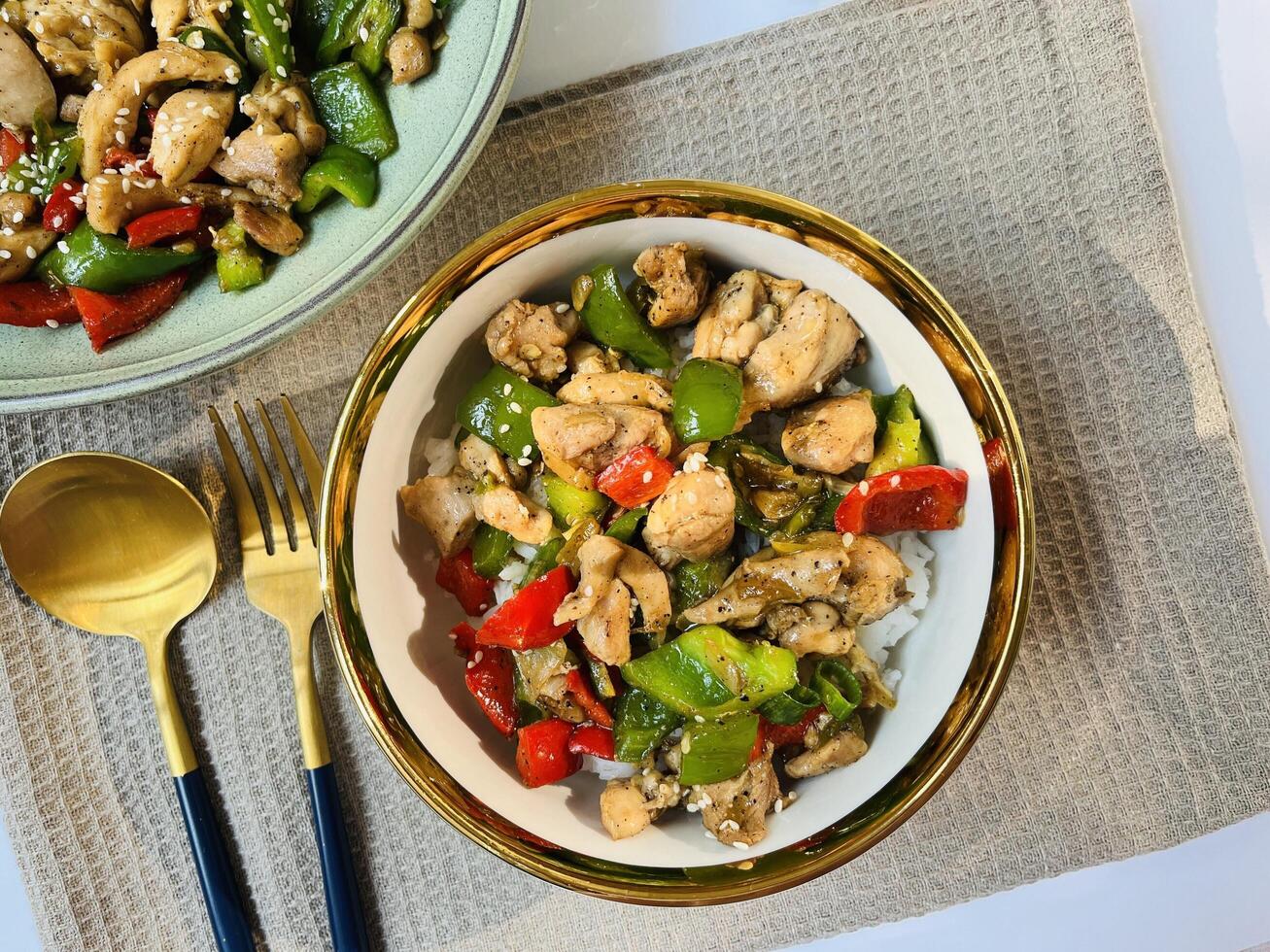 Black pepper chicken is stir-fried chicken breast with black pepper, paprika, garlic, onion and ginger. Served with rice on a bowl. Perfect for recipe, article, catalogue, or any cooking contents. photo
