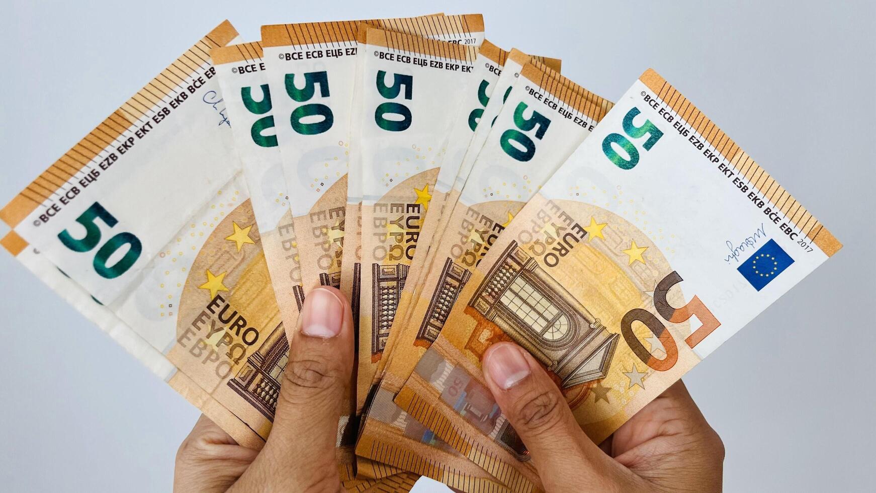 A closeup shot of hand holding 50 euro notes. Euro banknotes, European Union paper currency. Saving money concept. Finance, business, investment, inflation, purchasing power photo