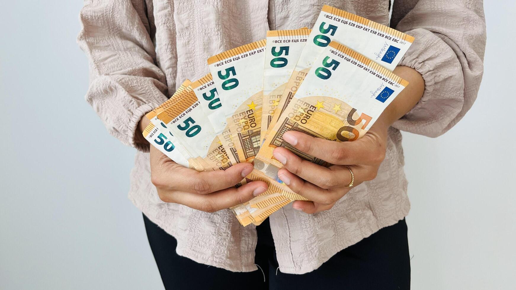 Woman holding euro money. Saving money concept. Finance, business, investment. Keeping savings at home. Spending cash for unexpected expense, unplanned losses, real estate, debts, taxes. photo