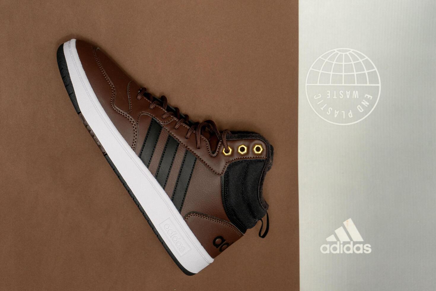 Evora, Portugal. March 3, 2024. Adidas brown boots on a matching brown background, highlighting sleek design and rugged texture. Perfect for outdoor adventures and style. photo