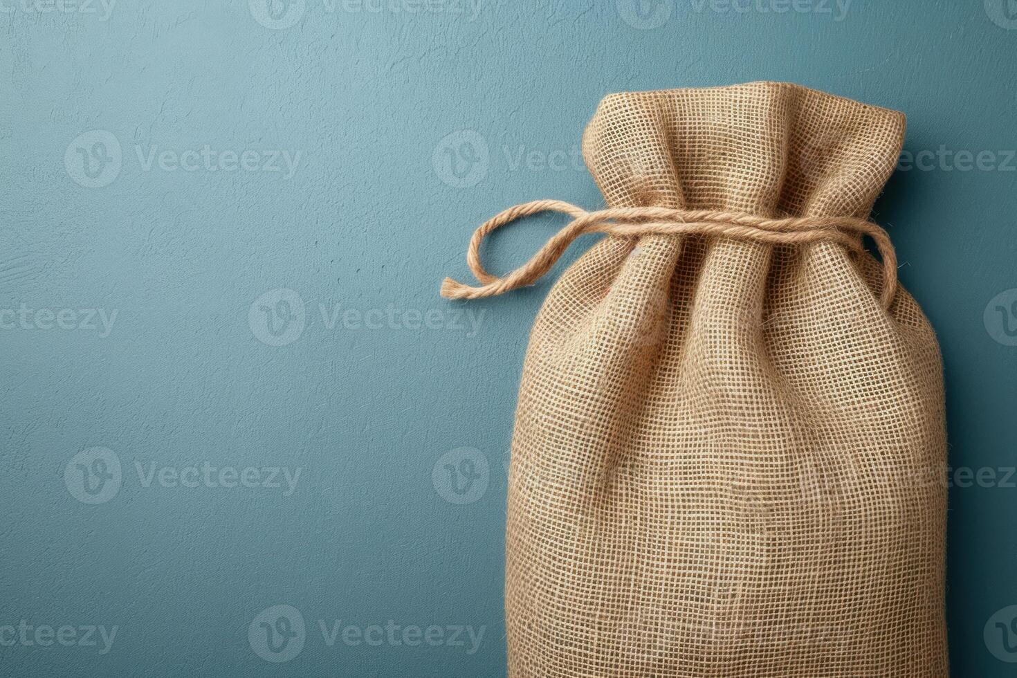 an empty pouch containing twine and string, with a blue wall in the background, photo