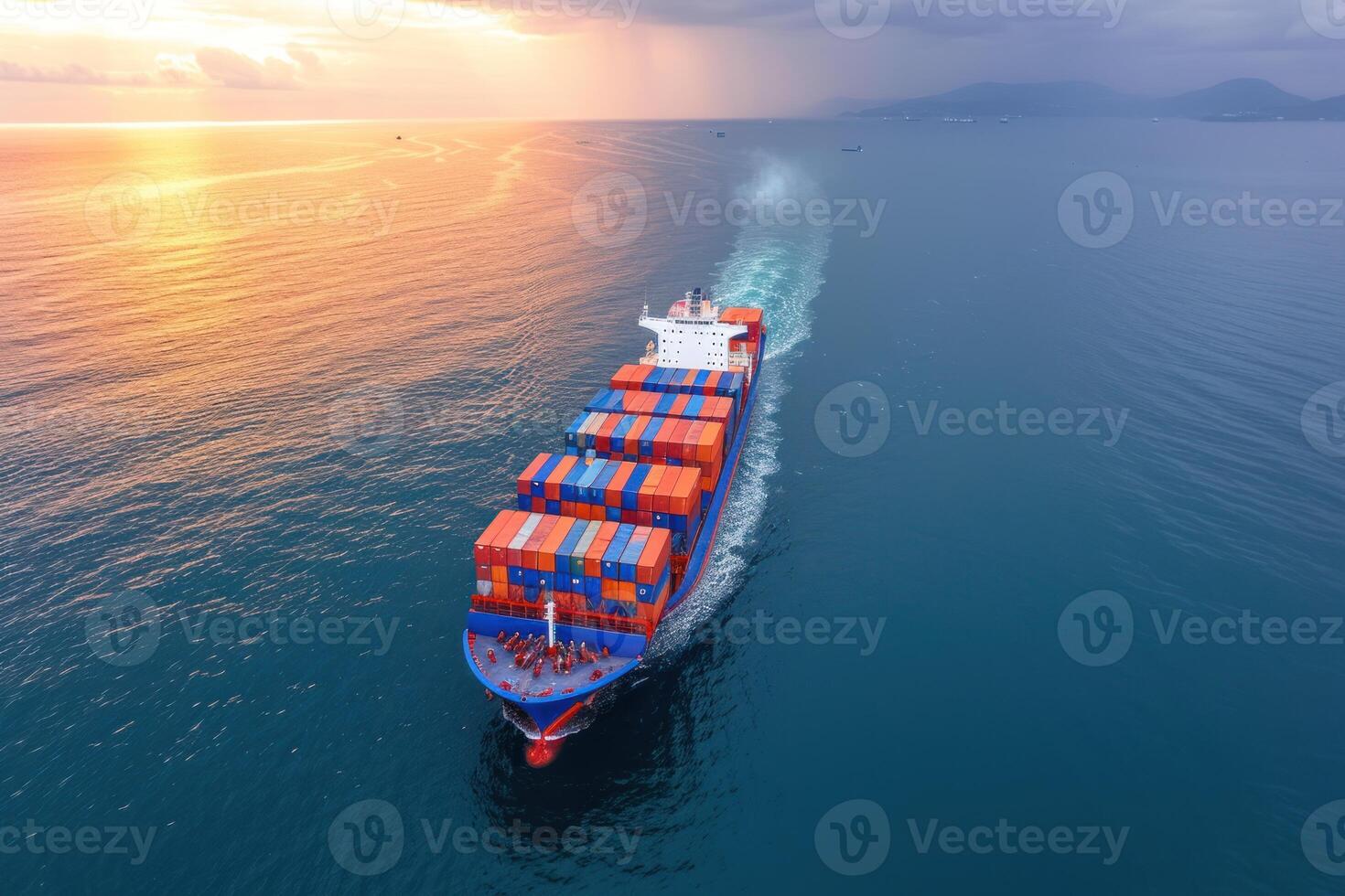 container ship heading through open blue ocean in yellow sunset, photo