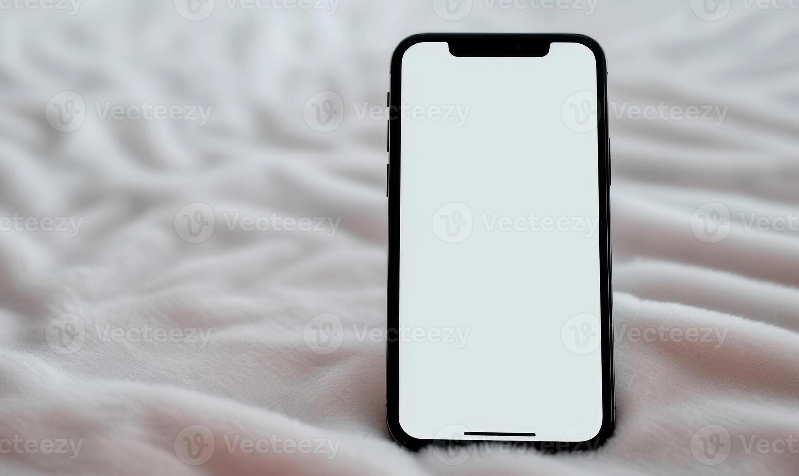 a blank white iphone next to some soft pink blankets, photo