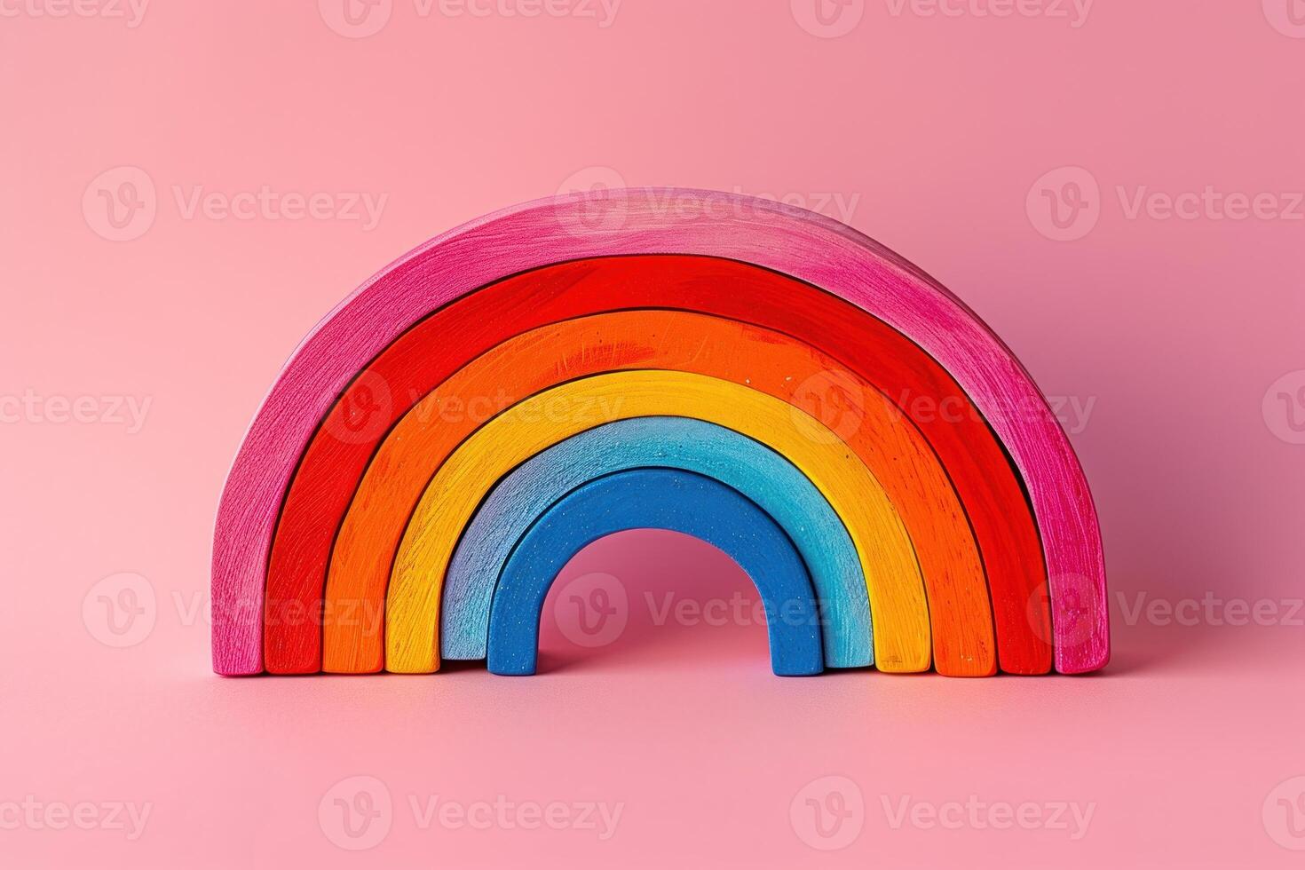 the rainbow figurine shown off to a side against a pink background, photo