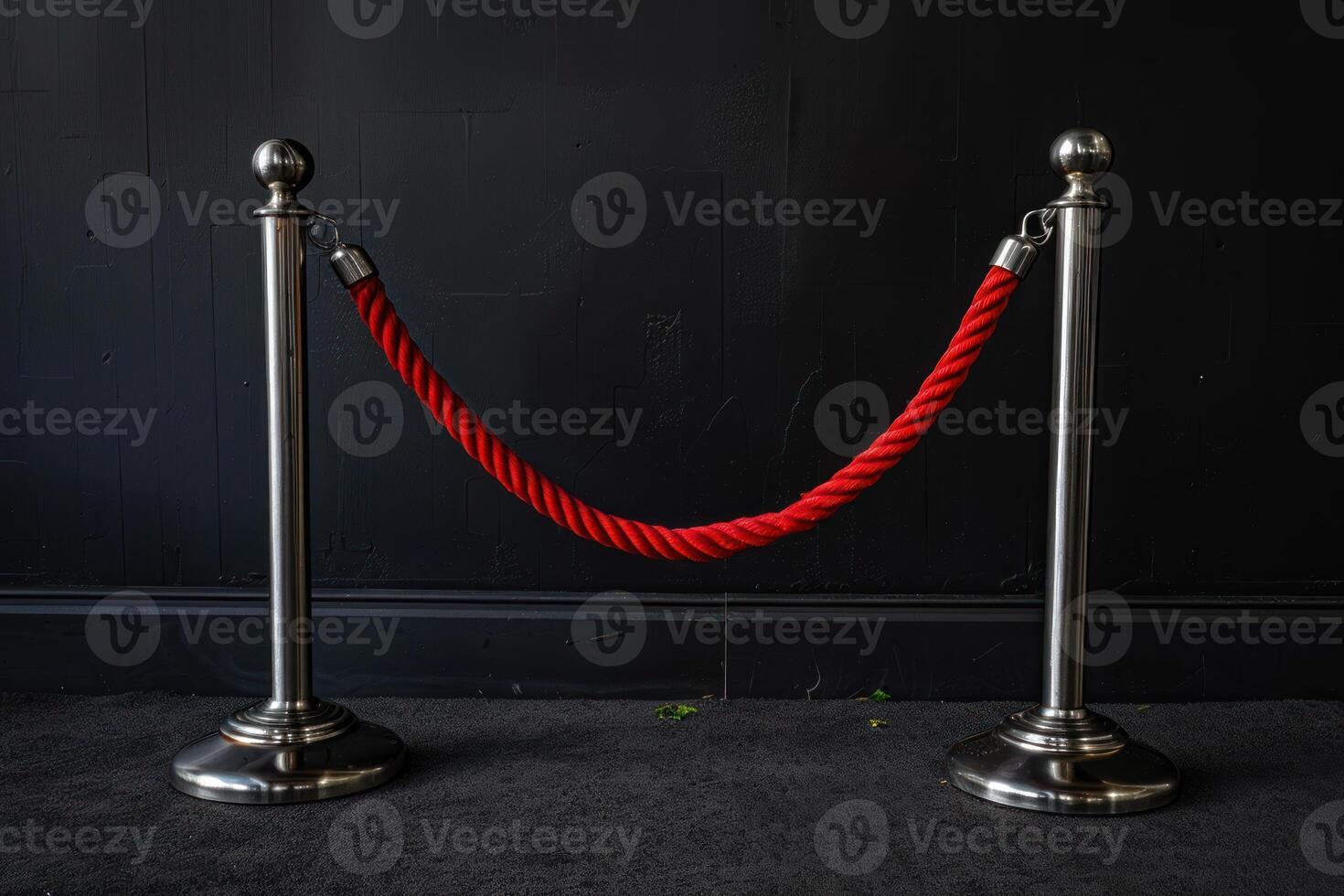 two chrome posts stand next to a rope that wraps around them, photo