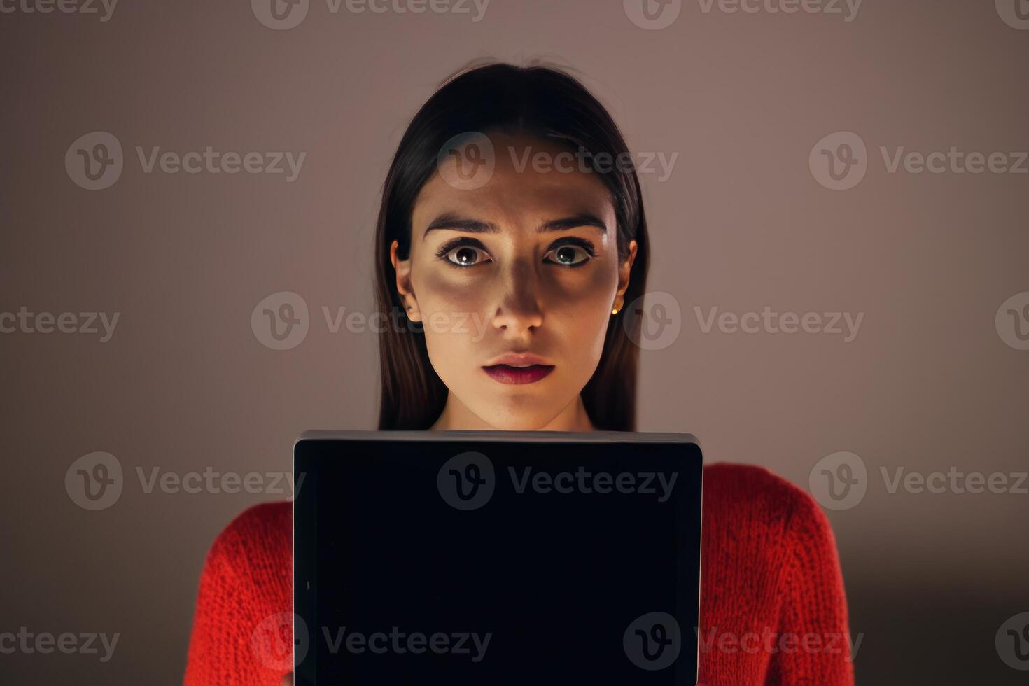 a woman posing holding a computer and looking at the screen, photo