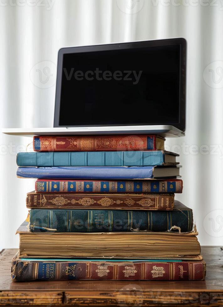a stack of old books and a laptop computer on top of one, photo