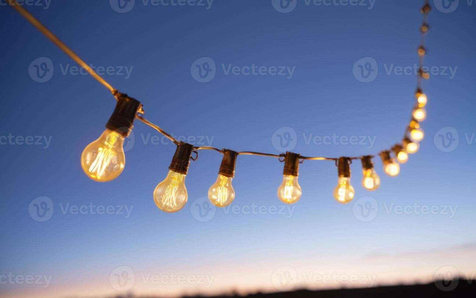 string of lights hanging high in the sky above a field, photo