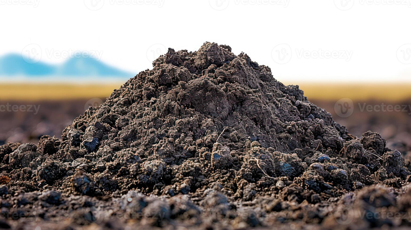 a pile of dirt sits in the middle of the field, photo