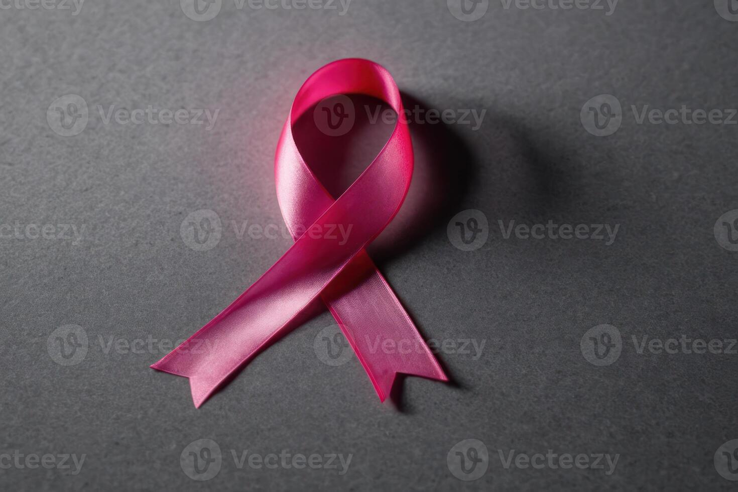 the end of a pink ribbon laying on to the surface, photo