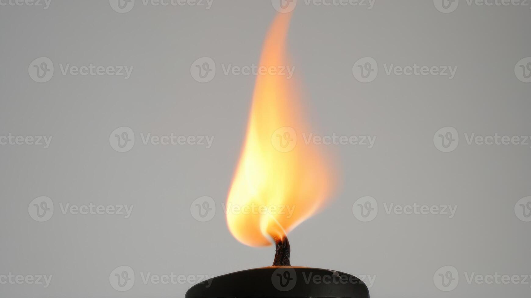 a candle burning brightly against a neutral grey sky, photo