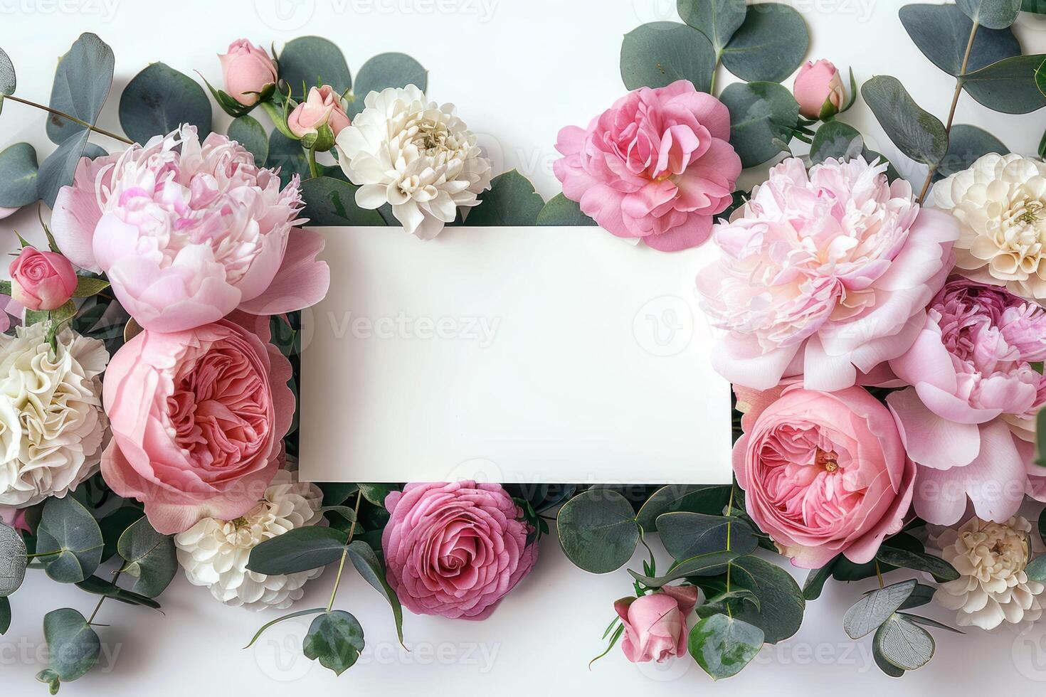 roses and foliage surround a business card that's on top of a white table, photo