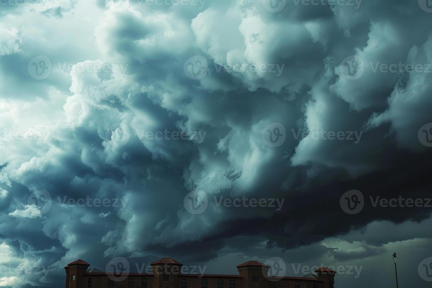 a very large storm moves in behind some buildings, photo