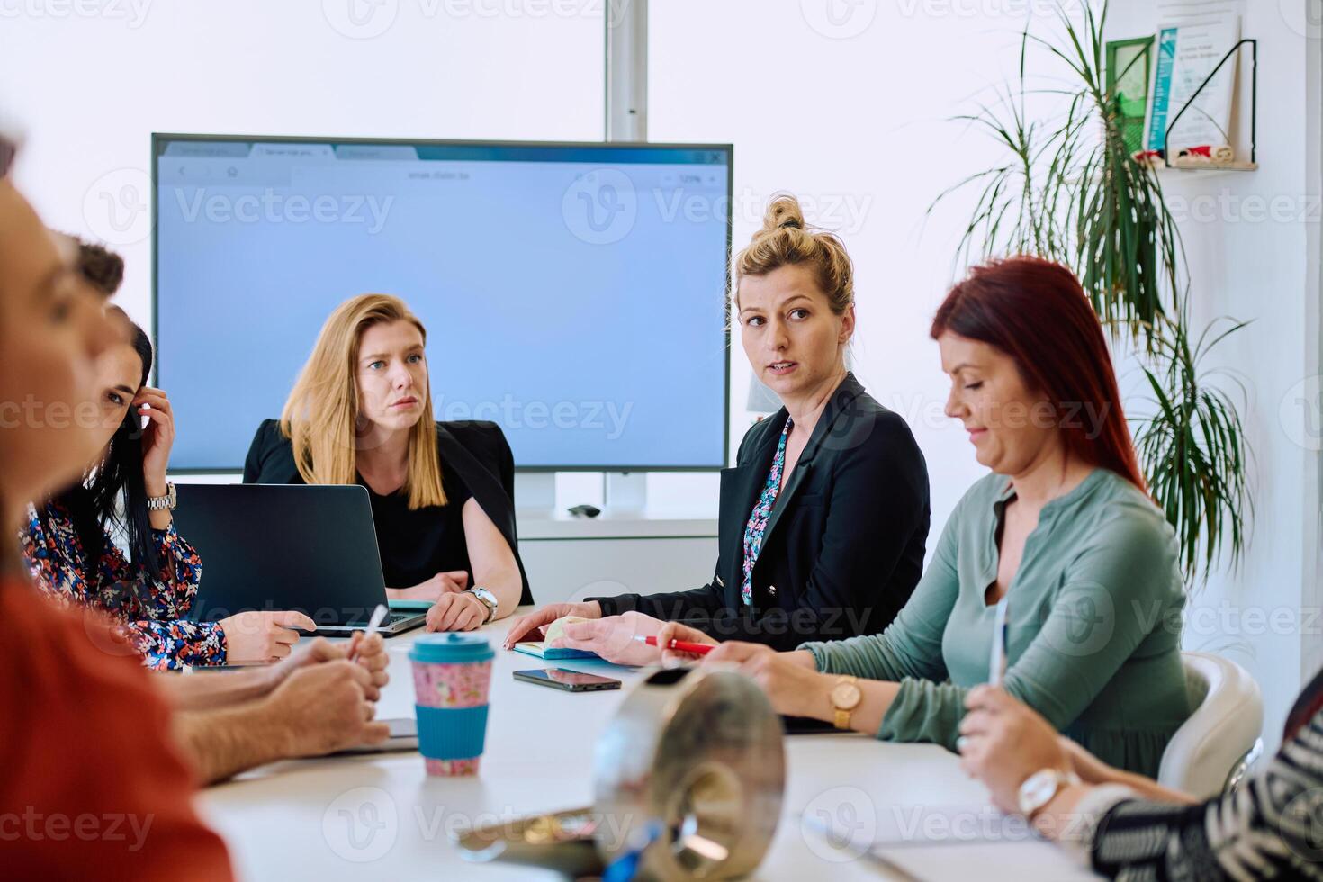Diverse Business Team Discussing Projects in a Modern Glass Office. photo