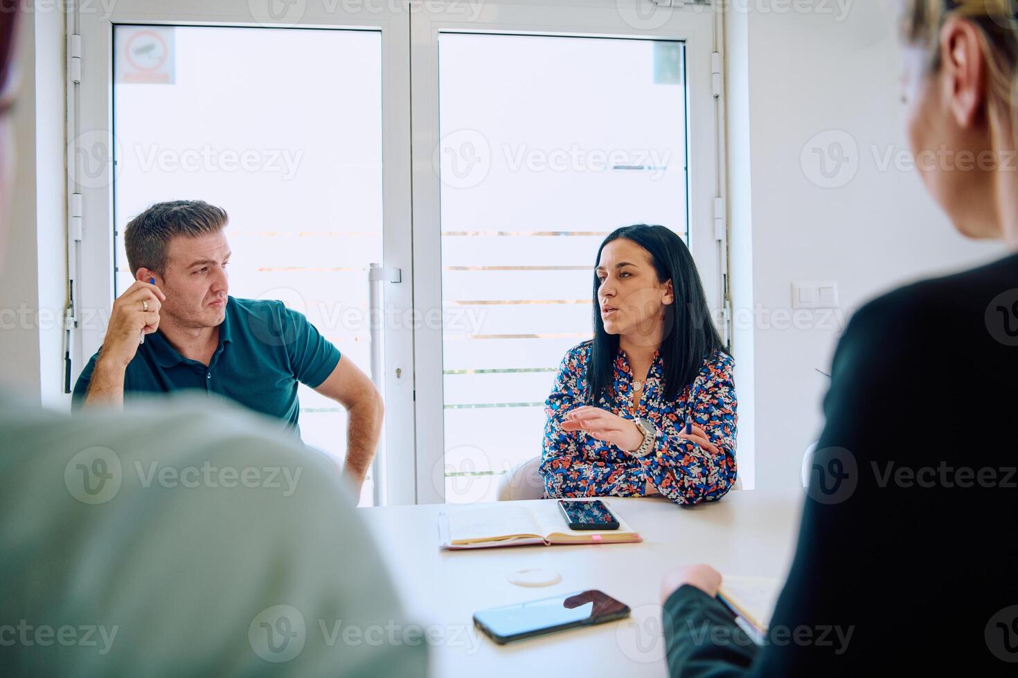 Diverse Business Team Discussing Projects in a Modern Glass Office. photo
