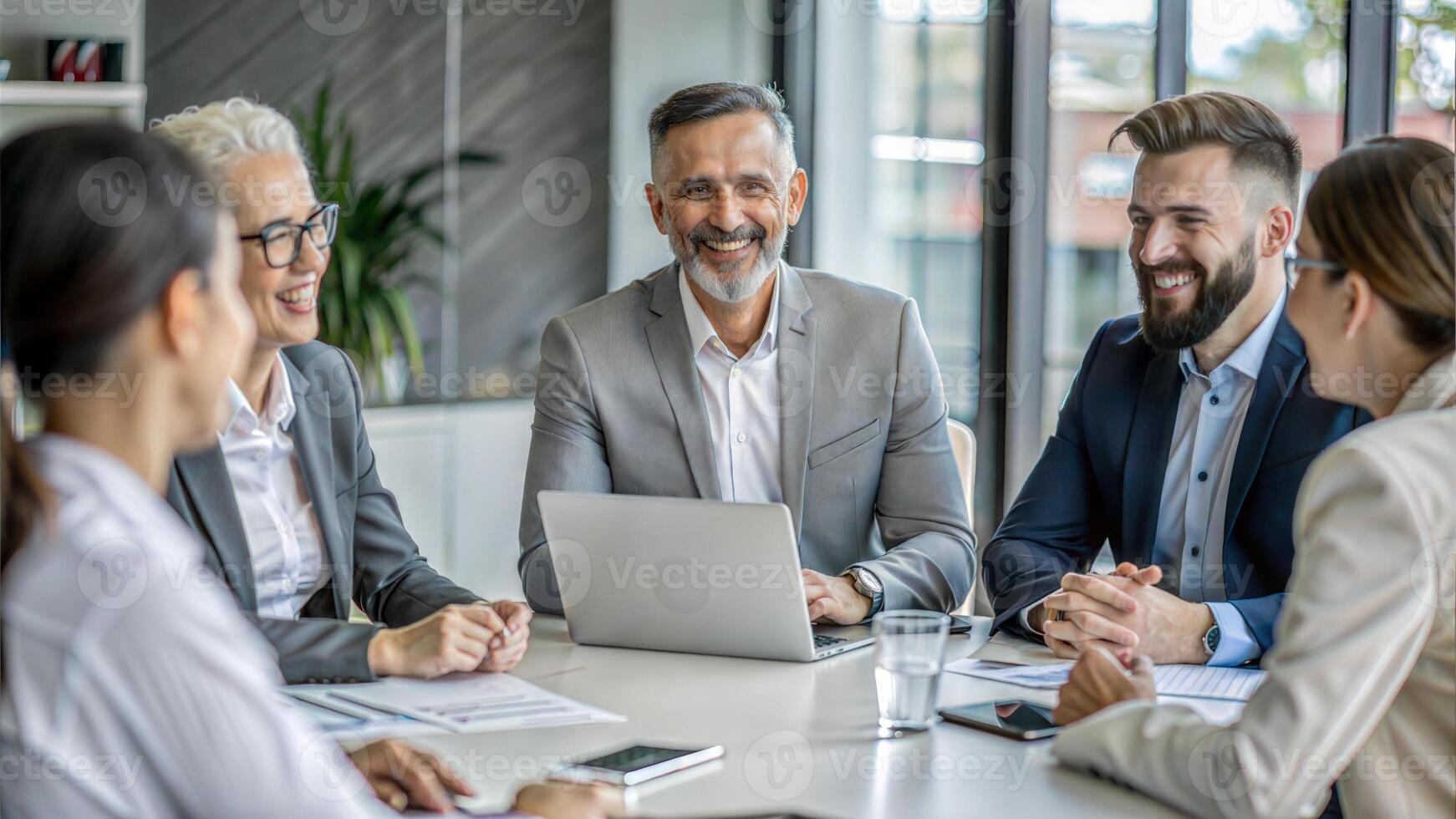 Group of business people working together at meeting in modern office. Businessmen and businesswomen working together on laptop computer. photo
