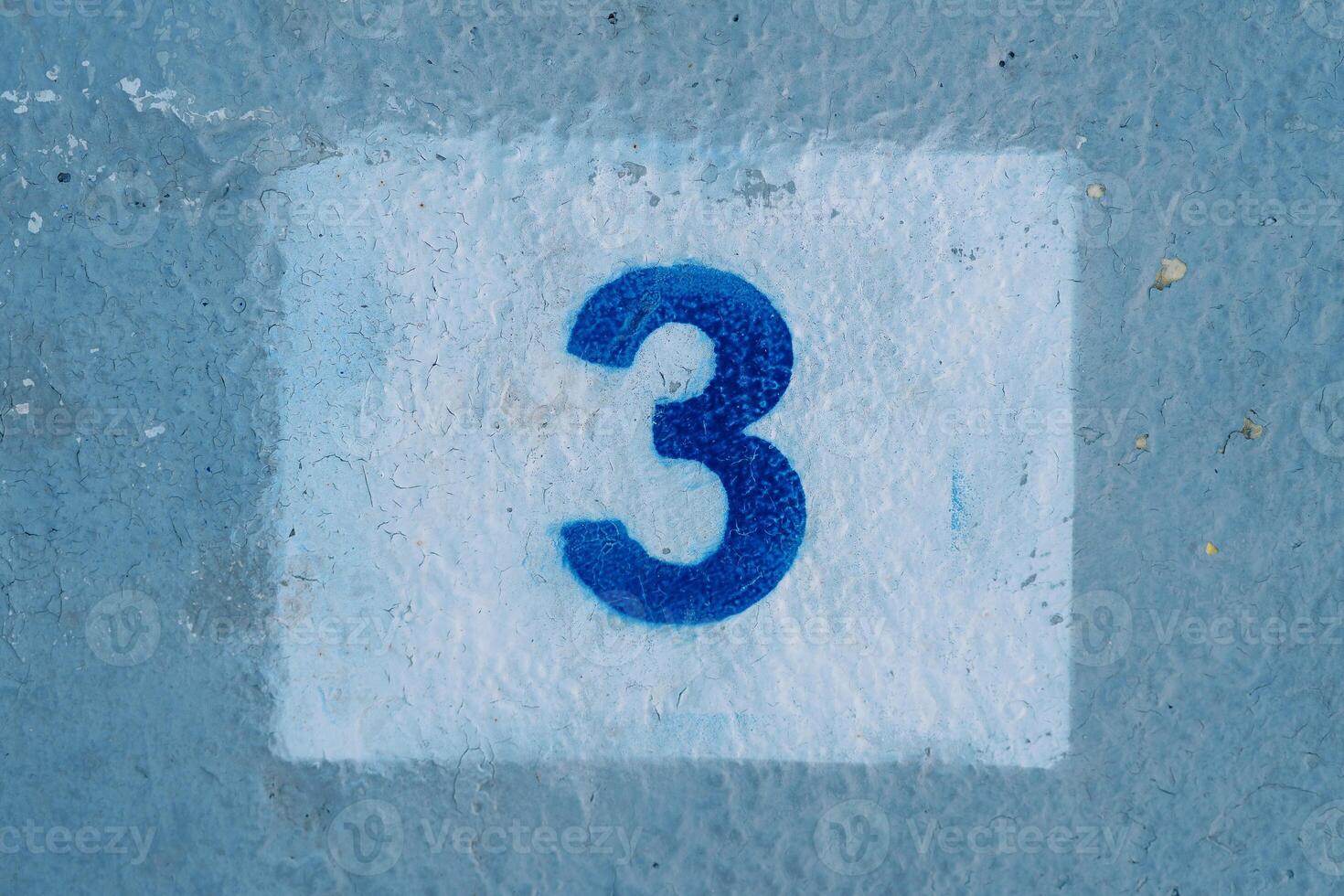 Number three drawn in a rectangle on a blue painted wall photo