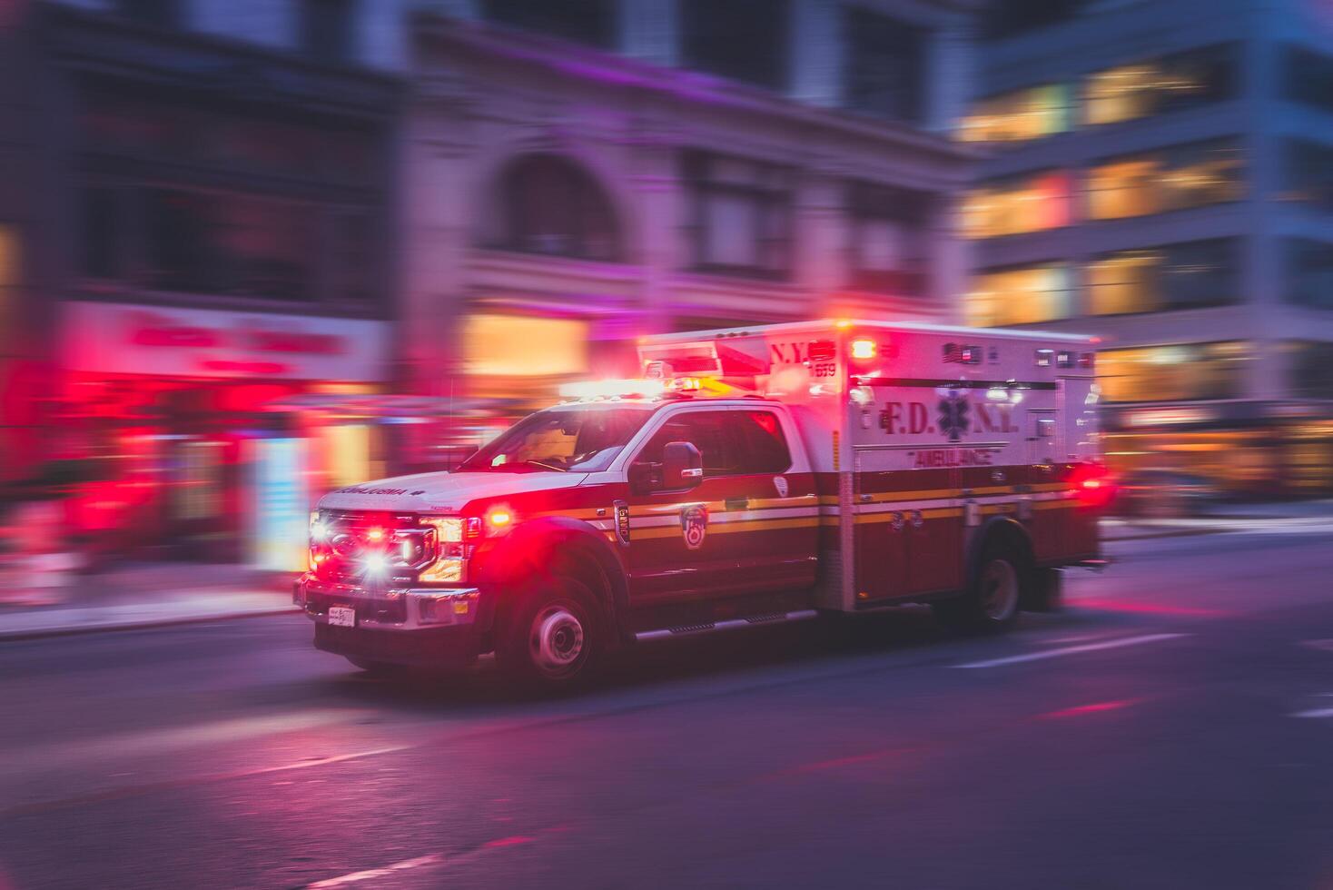 New York, US - May 8, 2023 - Ambulance flashing lights siren blasting speed through midtown rush hour traffic in Manhattan. Motion blur. photo