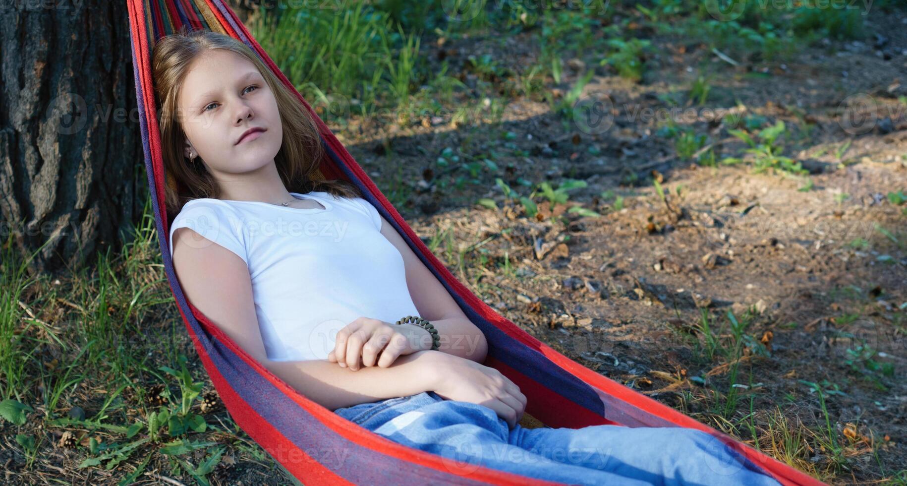thoughtful teenage girl reclines in a hammock, her introspective gaze suggesting she is navigating the emotional complexities of growing up with quiet contemplation photo