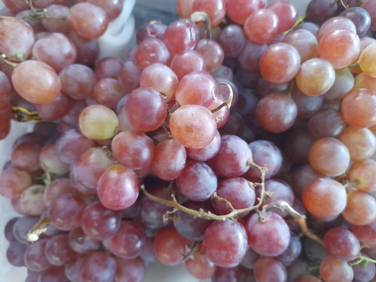 Ripe juicy sweet violet grape on the counter of the fruit store for sale photo