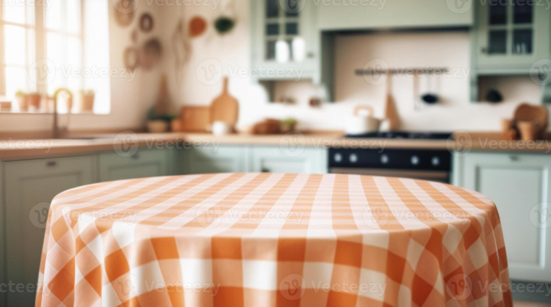 Empty round table with pastel orange and white checkered tablecloth top on blur kitchen background photo