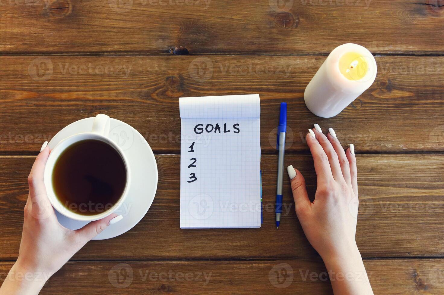 Crop woman writing goals in notepad photo
