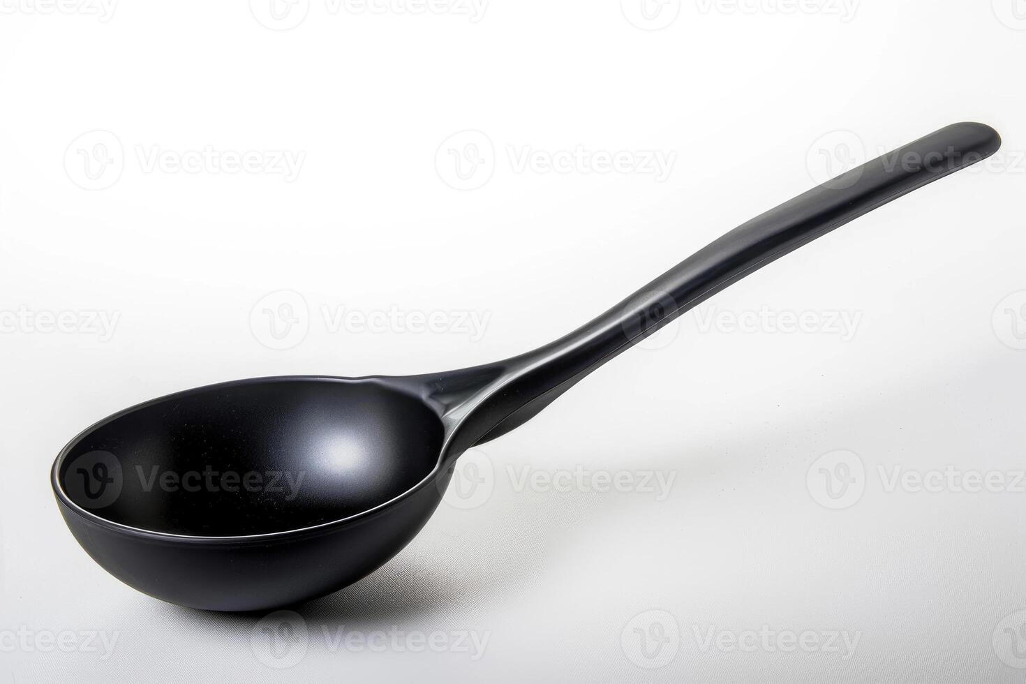 Black plastic soup ladle on a white background. photo