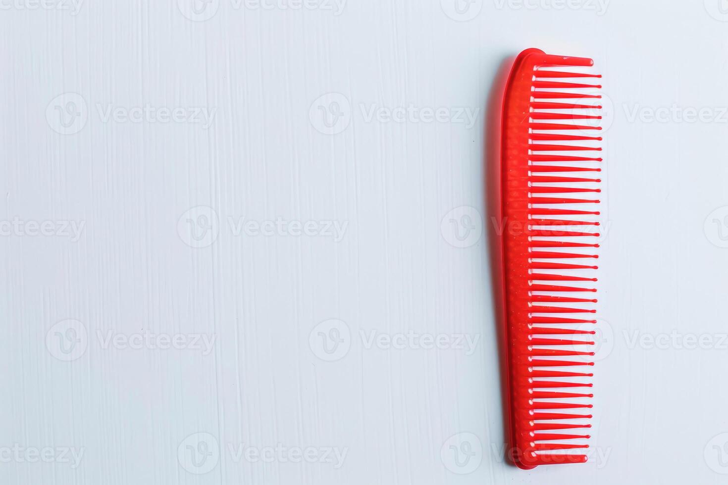 A red plastic comb isolated on a white background. photo