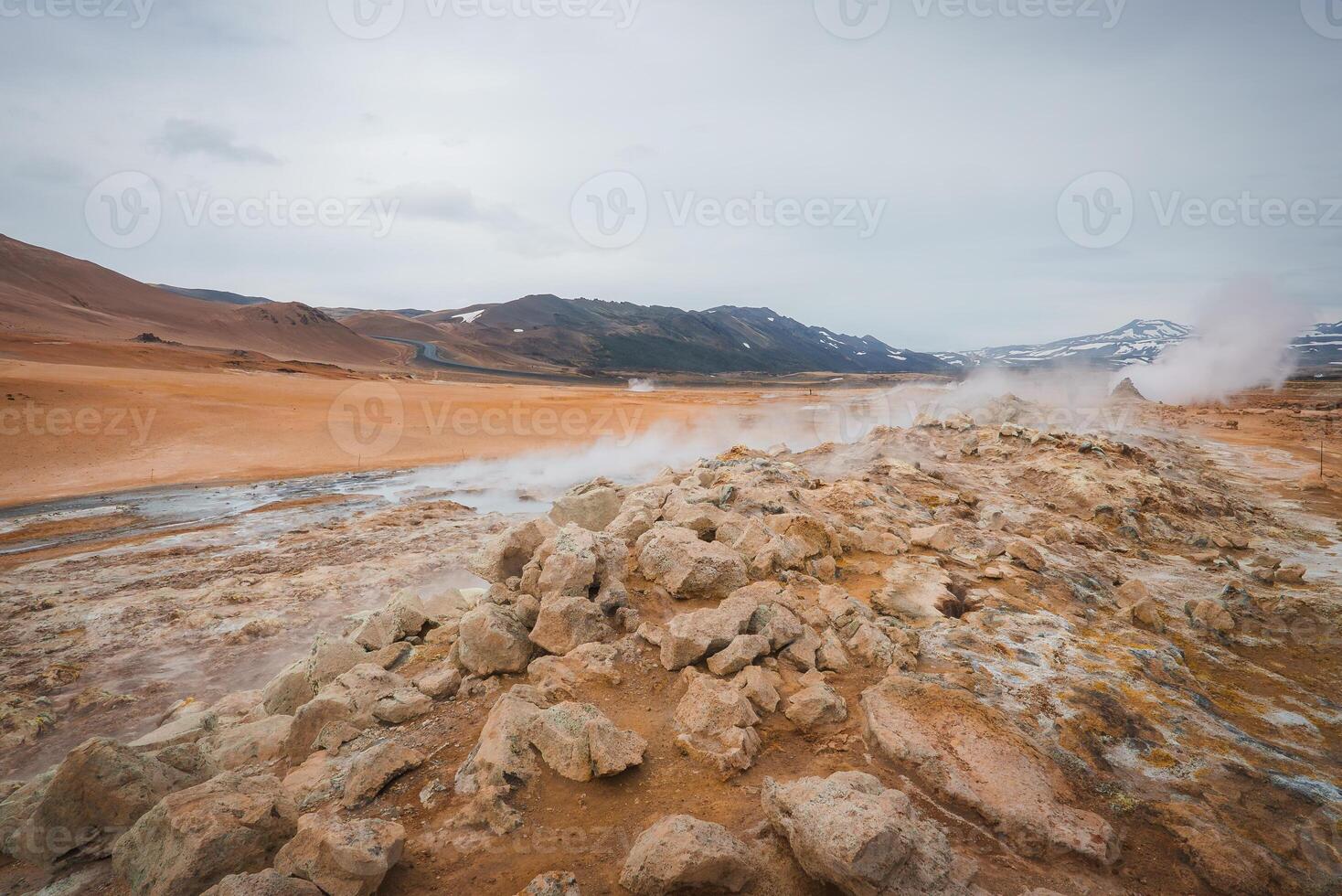Hverir Geothermal Area with Steam Fumaroles and Snow-Capped Mountains in Iceland photo