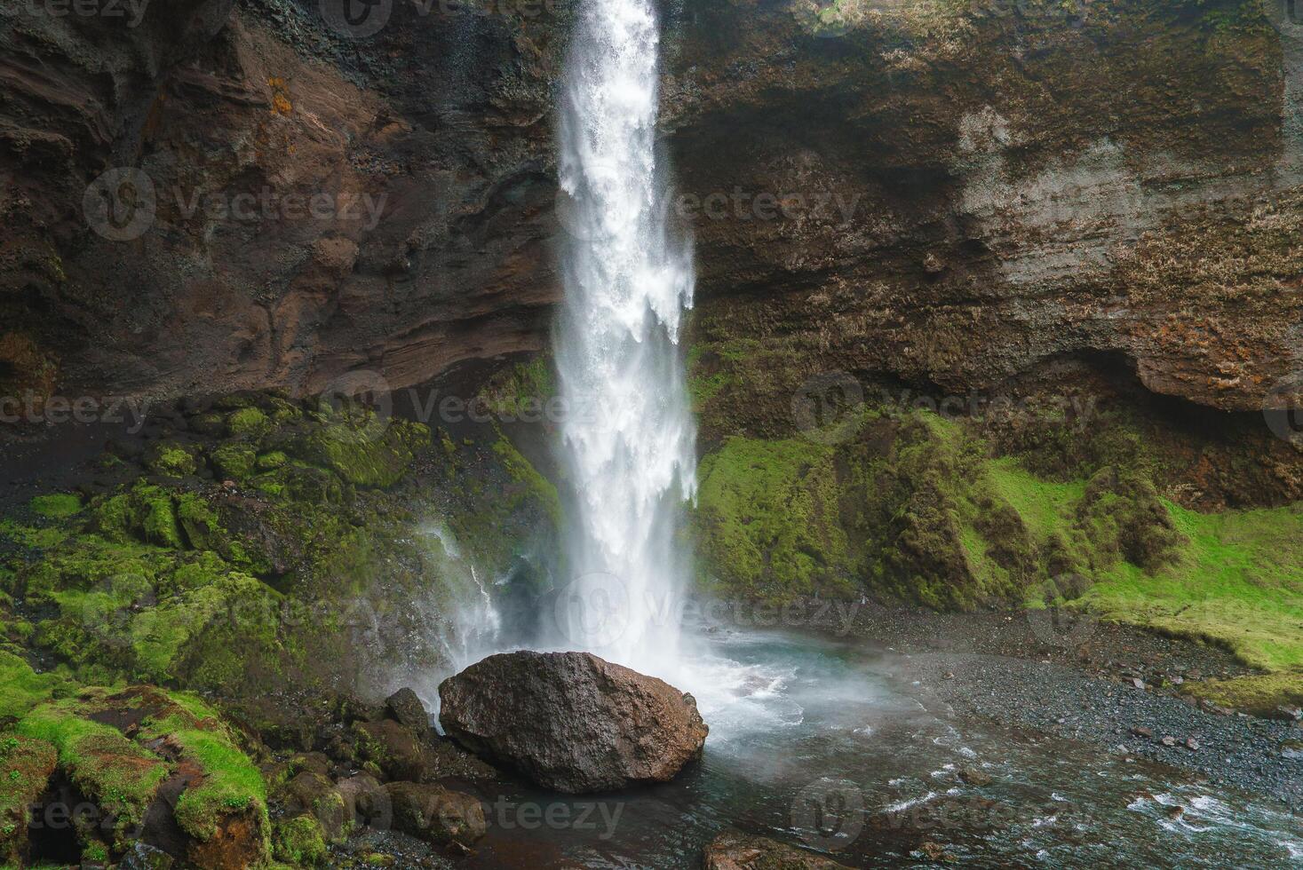 Majestic Waterfall Cascading Over Rocky Cliff in Icelandic Landscape photo