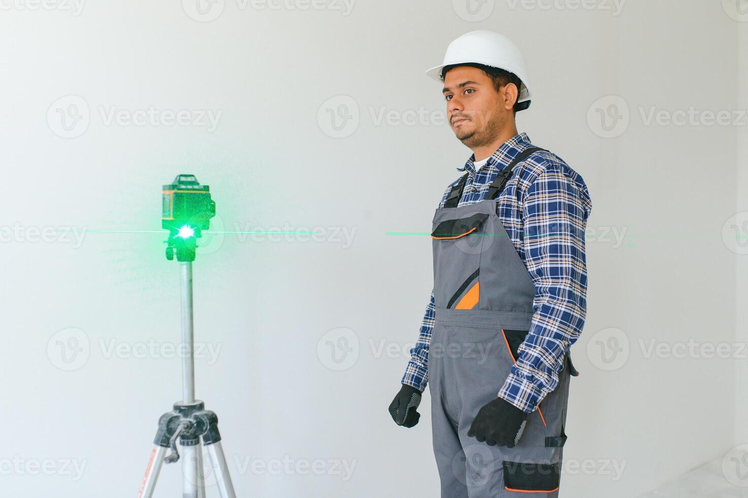 An Indian worker works in an empty apartment. A man in a uniform makes repairs inside the building photo