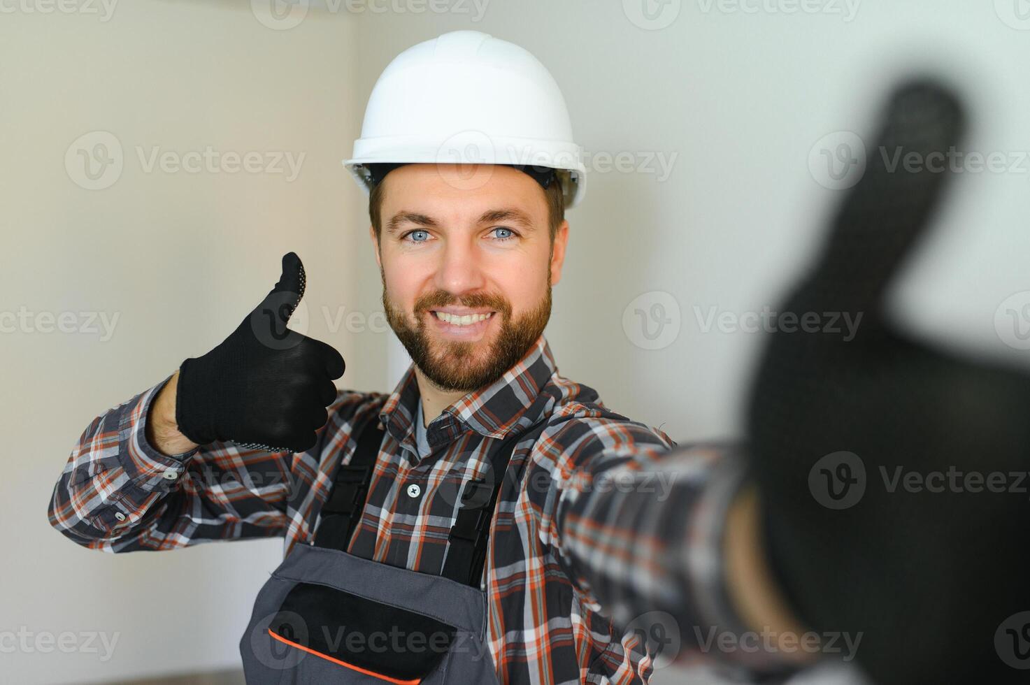 Portrait of a confident repairman with beard standing in empty apartment photo