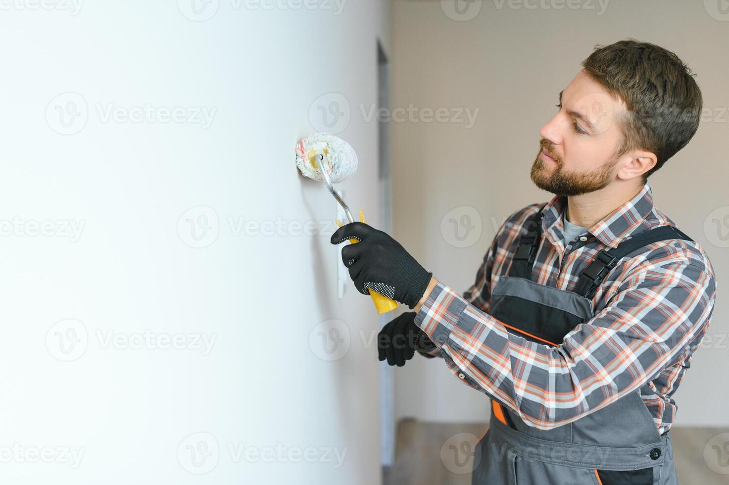 painter man painting the wall, with paint roller photo
