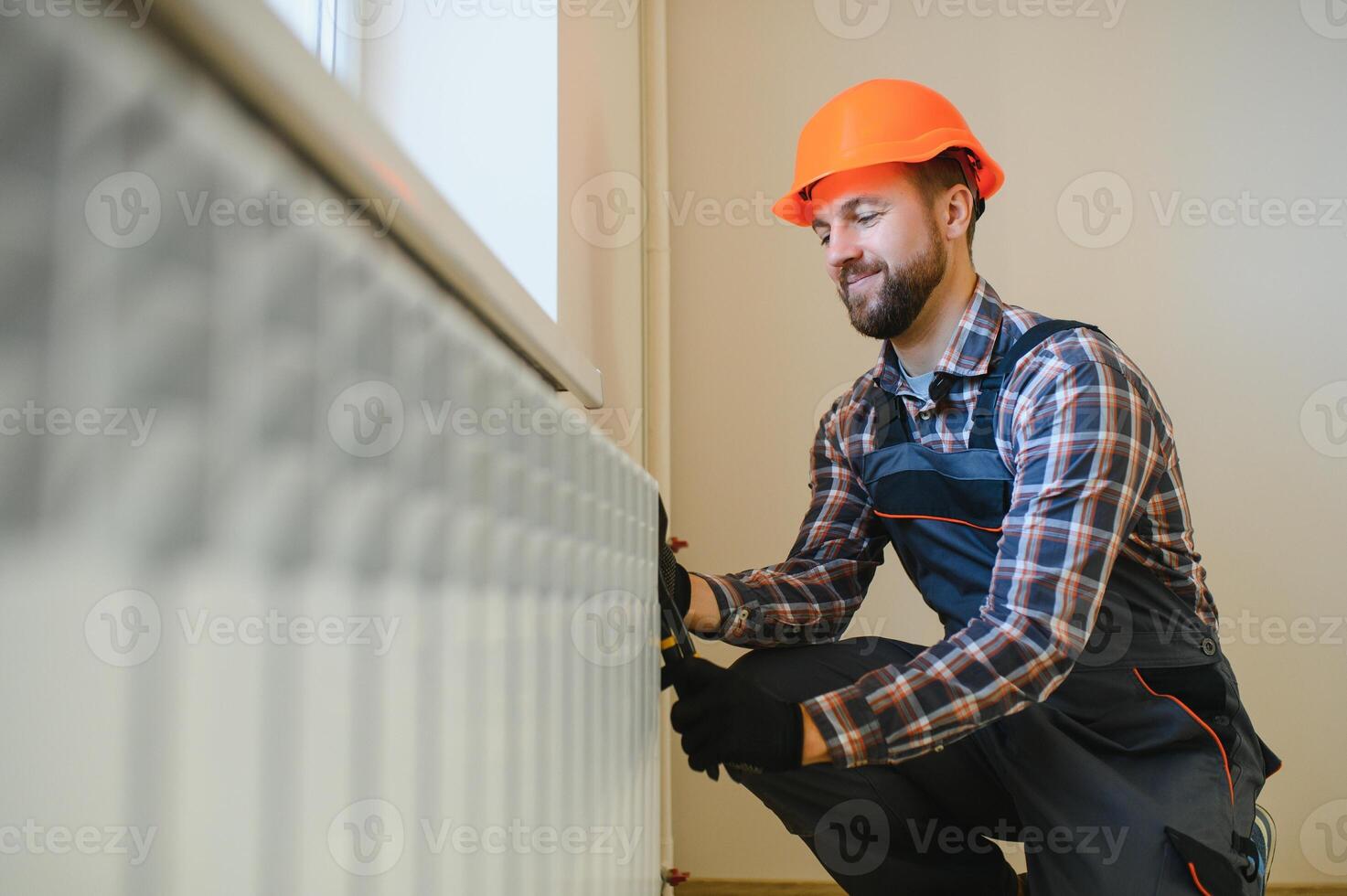 heating system installation and maintenance service. plumber installing radiator photo