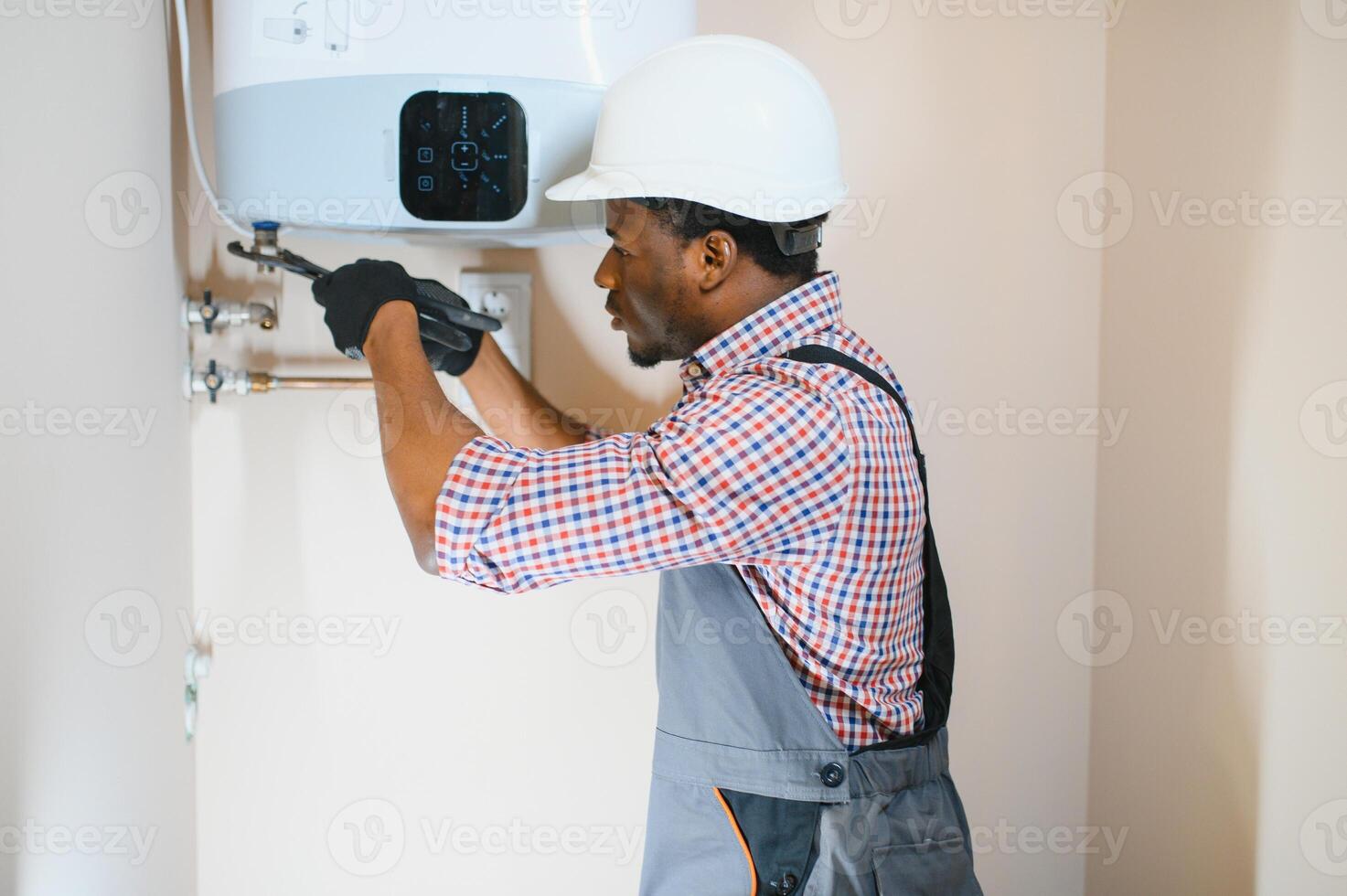 Professional engineer installing a natural gas boiler at home, he is checking the pipes photo