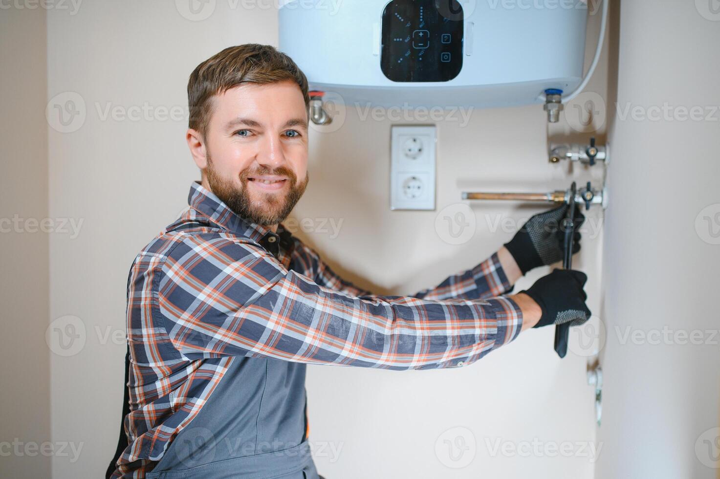 Professional engineer installing a natural gas boiler at home, he is checking the pipes photo